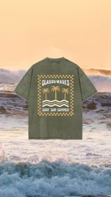 Remerón verde con efecto lavado y estampa en la espalda con palmeras, olas y texto 'Glassy Waves Surf Sun Summer'.