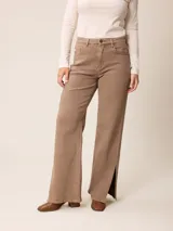 Pantalón jean de tiro alto y corte recto, color marrón chocolate, con aberturas laterales en el ruedo.