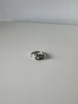 Anillo de acero quirúrgico con diseño de engaste tipo bisel que presenta una serie de piedras brillantes incrustadas en el frente.