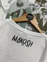 Remera blanca con estampado de un gato con anteojos de sol y mejillas rosadas, estilo Satoru Gojo de Jujutsu Kaisen.