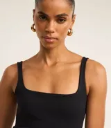 Vestido midi negro de punto roma, con escote cuadrado y corte ajustado.