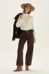 Camisa blanca de popelina elastizada con cuello alto con volados y mangas voluminosas.