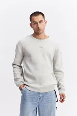 Sweater de algodón de calce relajado, con cuello redondo, mangas largas y puños y ruedo acanalados. Presenta un pequeño logo bordado en el centro del pecho.