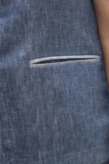 Chaleco azul de lino con cuello mao, abotonado al frente y bolsillos ojal con ribete blanco.