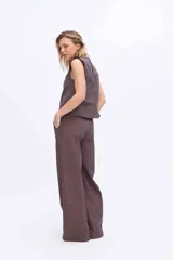 Pantalón de pierna amplia y tiro alto, confeccionado en tejido a rayas con una mezcla de algodón, poliéster y lino. Presenta un diseño de corte sastrero con bolsillos laterales y trabillas para cinturón.