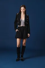 Top tipo corset de encaje negro con escote strapless y copas estructuradas. Presenta detalles de encaje con bordes festoneados y paneles transparentes en el torso.