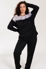 Pijama negro de algodón con detalle de puntilla bicolor en el escote. El pantalón es de tiro alto y corte recto.