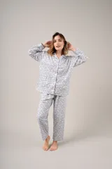 Pijama de dos piezas celeste con estampado floral, compuesto por camisa de manga larga abotonada y pantalón largo.