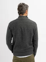 Buzo de tejido de punto color beige con cuello alto y cierre frontal parcial. Presenta puños y ruedo acanalados.