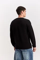 Sweater de punto texturizado color azul marino, de manga larga, con cuello polo en color beige contrastante.