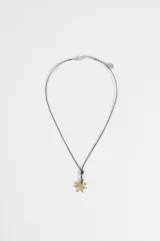 Collar de cordón negro con dije central en forma de estrella de textura rugosa en tono dorado.