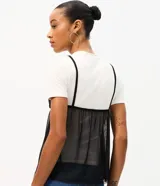 Remera baby tee de algodón con superposición de musculosa transparente de tul negro con breteles finos y escote en V.