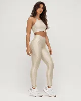 Calza deportiva de talle alto color beige metalizado, con diseño anatómico y bolsillo lateral.