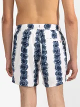 Short de baño blanco con estampado de rayas verticales con flores azules, cintura elástica con cordón ajustable, bolsillos laterales y trasero con cierre, suspensor de malla fina hipoalergénico.