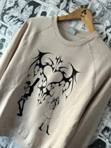 Buzo color beige con estampado de corazón tribal y personajes de anime.