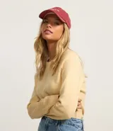 Suéter color amarillo pálido de punto liviano con cuello redondo y mangas largas raglán.