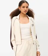 Campera deportiva de cuello alto con cierre frontal y bolsillos tipo canguro, en color beige con detalles marrones en las mangas y estampa localizada con texto "Phoenix Arizona".