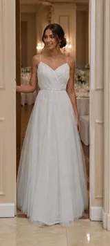 Vestido largo de novia con cuerpo drapeado y escote en V, confeccionado en encaje y tul. Presenta breteles finos y una cintura marcada con un delicado aplique de perlas, dando paso a una falda amplia con caída fluida.