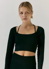 Top deportivo negro de manga larga, tejido de morley sin costuras. Presenta escote cuadrado y tiras finas cruzadas en la espalda.