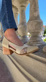 Sandalia de cuero legítimo con taco de madera, diseño cerrado con laterales abiertos y puntera fina texturizada con inserto brillante.