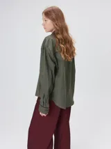 Camisa western de algodón grueso color verde militar, con corte holgado y aplicaciones de hilo en contraste en el pecho, la cartera de botones y los puños.