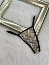 Pack de tres microtangas de encaje con diseño floral, cuentan con tiras laterales regulables y bordes con terminación en cinta elástica. El set incluye una prenda negra, una blanca con estampado floral negro y una beige con estampado floral negro.