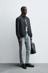 Cazadora de corte regular confeccionada en tejido técnico repelente al agua. Presenta cuello subido, manga larga con puños de rib, bolsillos laterales de vivo y cierre frontal con cremallera.