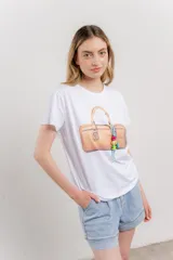 Remera blanca de algodón con estampado de un bolso con llavero colorido.