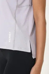 Remera deportiva lila de poliéster y elastano, con recortes laterales y traseros.