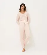 Pantalón de pijama tipo jogger confeccionado en viscolycra, con cintura elástica, cordón de ajuste y botamangas ajustadas. Presenta un estampado de perritos sobre una base de color rosado claro.