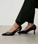 Zapato tipo scarpin de poliuretano con acabado liso, diseño de punta fina y recorte lateral tipo cutout. Cuenta con un tacón mediano de 7 cm, plantilla suave y forro textil.