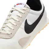 Championes Nike modelo Pre Montreal Racer Vintage, con diseño retro de perfil bajo. Presenta una base de tela técnica blanca con refuerzos de gamuza en tono gris claro en la puntera y el talón. Incluye el logo de Nike en color negro en los laterales y suela de goma con relieve para mayor tracción.