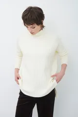 Polera de tejido acanalado en color blanco, con cuello alto, mangas largas y diseño de corte recto con aberturas laterales en el ruedo.