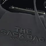 Bolso negro de nylon con asa superior anudada, correa cruzada de cuero ajustable y cierre magnético. Incluye bolsillo interior y bolsa de nylon con clip.