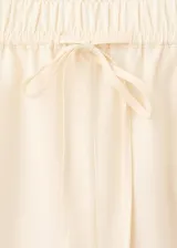 Pantalón de algodón color beige, de corte recto y silueta holgada. Cuenta con cintura elástica ajustable con cordón y detalles de bordado lateral.