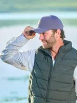 Gorra unisex de color beige con visera curva y aplique de cuero con logo grabado en el frente. Cuenta con hebilla metálica posterior para ajuste.