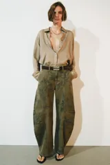 Jeans de tiro bajo y diseño barrel leg de la colección Zara Woman, en color verde militar con estampado floral en contraste, trabillas para cinturón y costuras decorativas frontales.
