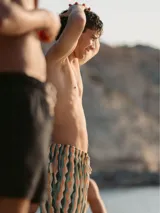 Short de baño para hombre con estampado de ondas en tonos beige, verde y celeste. Tiene cintura elástica con cordón ajustable, tres bolsillos y calzoncillo interior de malla.