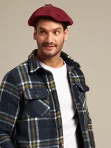 Boina azul marino de paño con visera corta y botón forrado en la parte superior.