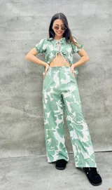 Pantalón palazzo verde con estampado de flores blancas, de tiro alto y corte holgado.