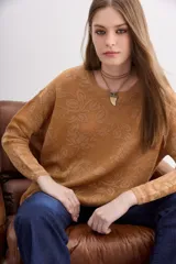 Sweater de moldería relajada, color camel, con escote redondo y manga larga. Tejido jacquard con diseño floral en lurex a tono que simula transparencias.