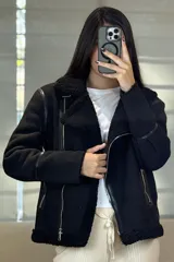 Campera tipo gamulán de color crema con interior y cuello de corderito sintético. Presenta cierre frontal cruzado, bolsillos laterales con cierre y detalles de costuras en contraste color marrón oscuro.