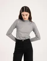 Polera gris de rib elastizado con brillos, cuello alto y mangas largas.