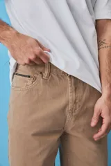 Pantalón de jean estilo baggy, de corte holgado y tiro medio, en color beige tostado, con diseño clásico de cinco bolsillos y trabillas para cinto.