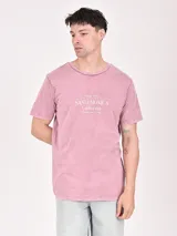 Remera color beige con estampa rectangular con diseño abstracto en tonos marrones y texto.