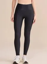Calza deportiva de tiro alto con diseño de alta compresión y textura acanalada con leve brillo. Cuenta con un bolsillo trasero en la cintura y tecnología de ajuste adaptable.