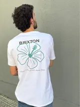 Camiseta blanca de manga corta con estampado en la espalda de una flor de hibisco azul y la frase "Where hibiscus grows, peace flow".