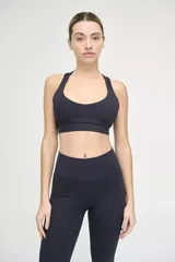 Top deportivo negro con escote redondeado, espalda cruzada y cintura con doble tela.