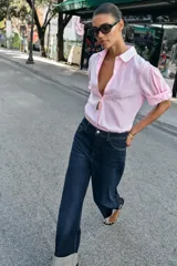 Jeans de tiro medio color azul oscuro, con cinco bolsillos, cierre de cremallera y botón. Presenta una silueta curvada, más ancha en el muslo y la rodilla, y un bajo con vuelta.