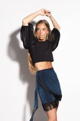 Falda tipo pareo corta, color azul metalizado con acabado brillante y flecos negros decorativos en el borde. Ajustable en la cintura.